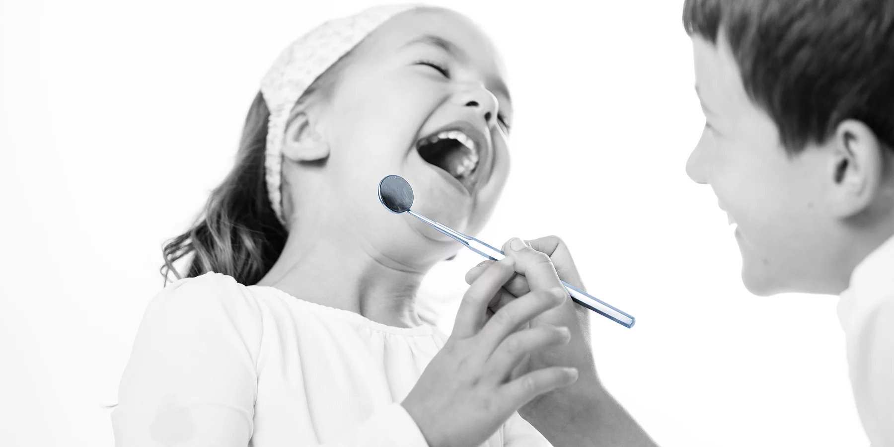Zwei Kinder beim Zahnarzt. Beide lächeln.